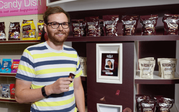 Shopper smiling with sample from Smile Sampler